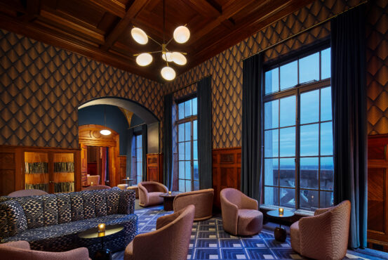 Sophisticated lobby of the W Hotel, featuring a grand room with a large window and a plush couch inviting comfort.